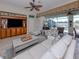Cozy living room with built-in shelving, ceiling fan and access to the outdoor living space at 162 Treviso Ct, North Venice, FL 34275