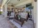 Covered patio with comfortable seating and a view of the lawn and landscaping at 162 Treviso Ct, North Venice, FL 34275
