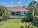 Aerial view of the screened pool with a red tile roof and tropical landscaping at 162 Treviso Ct, North Venice, FL 34275