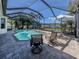 Screened pool with lake views features lounge chairs and lush tropical landscaping at 162 Treviso Ct, North Venice, FL 34275