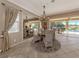 Dining room with elegant decor, wicker chairs, a round table, and a scenic outdoor view at 174 Treviso Ct, North Venice, FL 34275