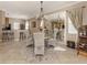 Cozy dining room with a round table, wicker chairs, chandelier, and a view reflected in a large mirror at 174 Treviso Ct, North Venice, FL 34275