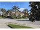 Circular driveway leads to a stately building entrance, enhanced by lush palm trees and manicured landscaping at 174 Treviso Ct, North Venice, FL 34275