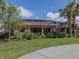 Backyard showcasing a screened-in lanai with an outdoor living area, manicured lawn and tropical foliage at 174 Treviso Ct, North Venice, FL 34275