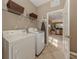 Functional laundry room equipped with a washer, dryer, shelving, and easy access to the kitchen at 174 Treviso Ct, North Venice, FL 34275