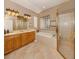 Bright main bathroom featuring a soaking tub, glass-enclosed shower, and dual sink vanity at 174 Treviso Ct, North Venice, FL 34275