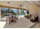 Inviting screened-in patio featuring an outdoor dining area, a comfortable seating arrangement, and a ceiling fan at 174 Treviso Ct, North Venice, FL 34275