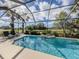 Tranquil pool area with comfortable lounge chairs, a fountain, and beautiful landscaping overlooking the golf course at 174 Treviso Ct, North Venice, FL 34275