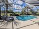 Beautiful pool area with lounge chairs, surrounded by a screened enclosure and views of the golf course at 174 Treviso Ct, North Venice, FL 34275