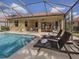 Inviting pool with chairs, umbrellas, and access to an outdoor dining area for relaxing and entertaining at 174 Treviso Ct, North Venice, FL 34275