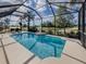 Inviting screened-in pool area with comfortable lounge chairs and lush landscaping at 174 Treviso Ct, North Venice, FL 34275