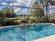 Inviting pool and patio area with water feature offering views of the lush golf course at 174 Treviso Ct, North Venice, FL 34275