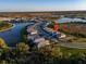 An aerial view showcases a new construction community by a large pond and natural surroundings at 17449 Luminous Ave, Venice, FL 34293
