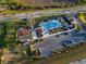 Aerial view of a community pool and playground with ample parking, surrounded by lush landscaping and sidewalks at 17449 Luminous Ave, Venice, FL 34293