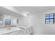 Well-lit bathroom featuring a double sink vanity with white cabinets, large mirror, and natural light from windows at 17449 Luminous Ave, Venice, FL 34293