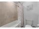 Cozy bathroom featuring a shower-tub combo with colorful polka-dot curtain at 17449 Luminous Ave, Venice, FL 34293