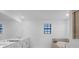 Bright bathroom with double vanity, white cabinets, soaking tub, neutral tile, and a window with blinds at 17449 Luminous Ave, Venice, FL 34293
