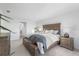 A well-lit bedroom featuring neutral walls, carpet flooring, with a wooden bed frame and side tables at 17449 Luminous Ave, Venice, FL 34293