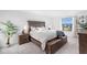 A bright bedroom features neutral walls, carpet flooring, and a wooden bed frame and side tables at 17449 Luminous Ave, Venice, FL 34293