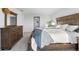 Bright bedroom featuring neutral walls, carpet flooring, wooden bed frame, dresser, and view of the hallway at 17449 Luminous Ave, Venice, FL 34293