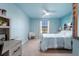 Charming bedroom featuring blue walls, a ceiling fan, and a cozy window seat at 17449 Luminous Ave, Venice, FL 34293