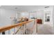 Upstairs hallway featuring a wooden staircase and view of a cozy seating area at 17449 Luminous Ave, Venice, FL 34293