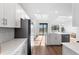 Bright kitchen and living space features white cabinets and quartz countertop island at 17449 Luminous Ave, Venice, FL 34293