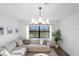 Bright living room featuring a sectional sofa, large window, and contemporary light fixture at 17449 Luminous Ave, Venice, FL 34293