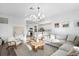 Open-concept living room with a sectional sofa, wood floors, and a view of the kitchen at 17449 Luminous Ave, Venice, FL 34293