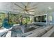 Covered patio area with comfortable seating, overhead fan, peaceful views of the landscape, and cozy lights at 1837 Upper Cove Ter, Sarasota, FL 34231