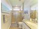 Bathroom featuring a glass door shower, a white sink vanity, a beige tile floor, and neutral paint at 18900 Bianchi St, Venice, FL 34293