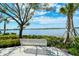 Relaxing view of the lake with seating under shade trees and various green landscaping on a beautiful day at 19180 Mangieri St, Venice, FL 34293