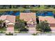 Aerial view of home showcasing its tile roof, paver driveway, and beautiful waterfront location on a serene pond at 19651 Quisto St, Venice, FL 34293