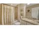 Bathroom featuring granite counters, framed art, framed mirror, and tile shower with decorative shower curtain at 19651 Quisto St, Venice, FL 34293