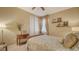 Cozy bedroom features neutral walls, carpet flooring, ceiling fan, and window with curtains at 19651 Quisto St, Venice, FL 34293