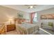 Cozy bedroom featuring a ceiling fan, patterned bedding, two bedside tables and lamps at 19651 Quisto St, Venice, FL 34293