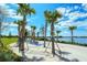 Relaxing hammock area by the lake, with palm trees providing shade and creating a tranquil outdoor space at 19651 Quisto St, Venice, FL 34293