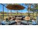 A cozy outdoor lounge area with a fire pit, comfortable seating, and serene waterfront views at 19651 Quisto St, Venice, FL 34293