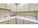Laundry room features washer and dryer, sink, ample cabinet space, and laminate countertop at 19651 Quisto St, Venice, FL 34293