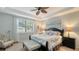 Serene primary bedroom with a tray ceiling, soft lighting, and a comfortable seating area at 19651 Quisto St, Venice, FL 34293