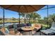Inviting screened-in patio featuring a cozy seating area, fire pit, and scenic water view at 19651 Quisto St, Venice, FL 34293