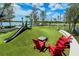Bright playground featuring a slide, swings, and chairs, creating a fun, outdoor recreational space by the waterfront at 19651 Quisto St, Venice, FL 34293