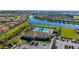 Aerial view of a large community pool with ample seating, a clubhouse, and well-maintained grounds at 19651 Quisto St, Venice, FL 34293