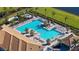 Aerial view of an expansive swimming pool area with lounge chairs, palm trees, and modern amenities at 19651 Quisto St, Venice, FL 34293