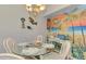 The dining area features a chandelier, beachy mural, and table set for four at 200 Mirabella Cir # 102, Venice, FL 34292