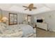 Tranquil main bedroom with light colors, tray ceiling, and natural light streaming through plantation shutters at 200 Mirabella Cir # 102, Venice, FL 34292