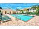 Community swimming pool surrounded by lush landscaping and lounge chairs under a bright blue sky at 200 Mirabella Cir # 102, Venice, FL 34292