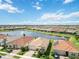 A scenic aerial view of a lakeside community showcasing homes with terracotta roofs and lush landscaping at 20389 Minuet Pl, Venice, FL 34293