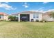 Well-maintained backyard with lush lawn and screened lanai perfect for outdoor gatherings at 20389 Minuet Pl, Venice, FL 34293