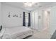 Bedroom with a striped twin bed, window with dark curtains and access to the hallway at 20389 Minuet Pl, Venice, FL 34293